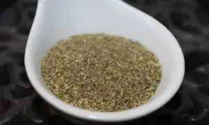 En vit skål fylld med italiensk salladskrydda, redo att ge smak åt din måltid.