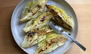 Ugnsbakad spetskål med citron och örter på en tallrik. En sked ligger bredvid.