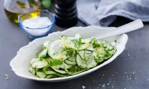 En fräsch zucchini sallad med citronzest och örter, serverad i en vit skål.