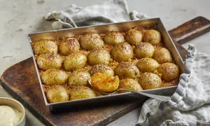 Ugnsbakade, krossade potatisar med parmesan och örter, redo att serveras.