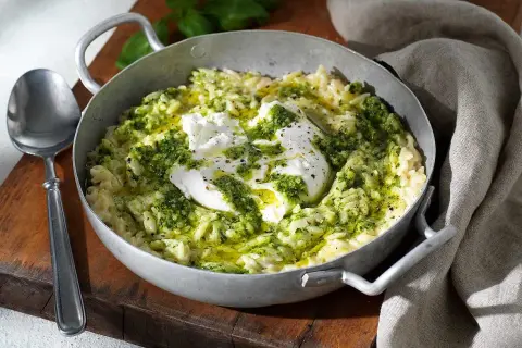 En skål med krämig risoni, toppad med färsk mozzarella och grön pesto. Ett perfekt risoni recept för en snabb och smakrik måltid.