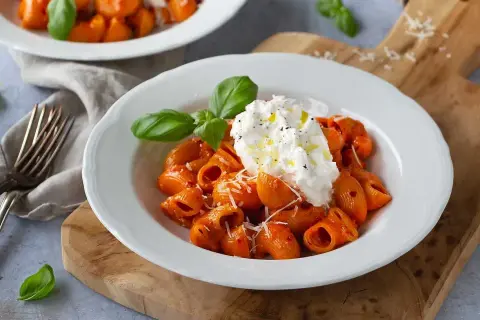 Nduja pasta med krämig burrata, toppad med basilika och olivolja. En härlig italiensk rätt.