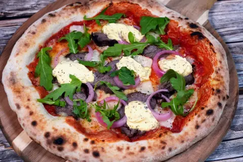 En läcker pizza med oxfilé, röd lök, ruccola och en krämig sås. Perfekt för en mysig kväll.