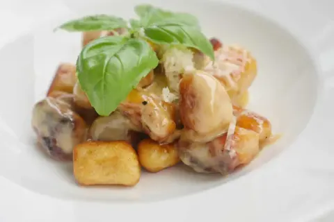 Gylla, gyllene gnocchi i krämig sås, toppad med färsk basilika. En härlig rätt att steka gnocchi i.