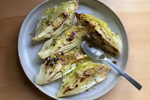 Ugnsbakad spetskål med citron och örter på en tallrik. En sked ligger bredvid.