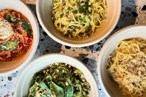 Fyra skålar med pasta, en med röd sås och burrata, en med pesto och pinjenötter, och två med ost och peppar. En hyllning till cucina povera.