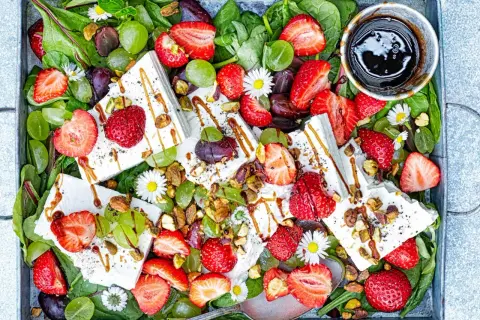 Sommarfräsch sallad med jordgubbar och fetaost, gröna druvor, nötter och en balsamico-dressing.