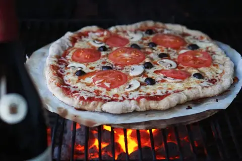 En grillad pizza med tomater, champinjoner och oliver. Perfekt för ett enkelt pizzadeg recept.