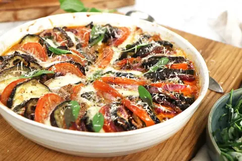 Gratinerad aubergine, tomat och mozzarella med färska örter. En härlig ugnsrätt som doftar sommar.