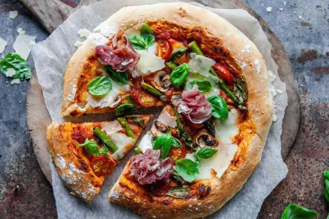 En härlig italiensk pizza med sparris, parmaskinka, champinjoner och färsk basilika.