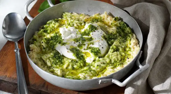 En skål med krämig risoni, toppad med färsk mozzarella och grön pesto. Ett perfekt risoni recept för en snabb och smakrik måltid.