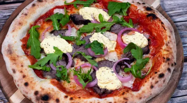 En läcker pizza med oxfilé, röd lök, ruccola och en krämig sås. Perfekt för en mysig kväll.