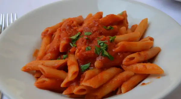 En tallrik med penne arrabiata, en kryddig tomatsås som betyder "arg" på italienska. Garnerad med färsk persilja.