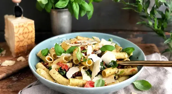 En härlig italiensk pastasallad med pesto, soltorkade tomater och pinjenötter. Serveras med färsk basilika och parmesan.
