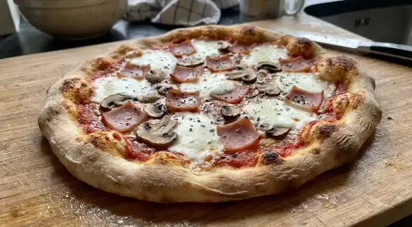 En hemmagjord pinsa med skinka och champinjoner, perfekt för ett mysigt kvällsmål. Detta pinsa recept ser fantastiskt ut!
