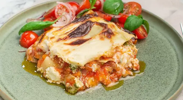 En bit krämig pesto lasagne med en fräsch tomatsallad.