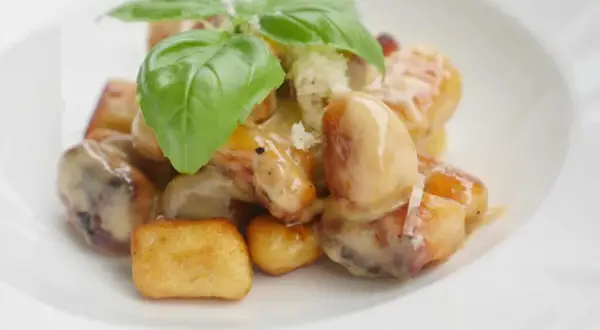 Gylla, gyllene gnocchi i krämig sås, toppad med färsk basilika. En härlig rätt att steka gnocchi i.