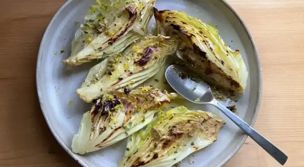 Ugnsbakad spetskål med citron och örter på en tallrik. En sked ligger bredvid.