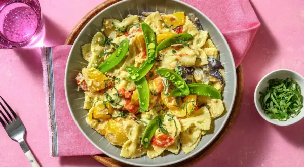 En krämig grekisk pastasallad med farfalle, sockerärtor och soltorkade tomater. Perfekt för en lätt lunch eller middag.
