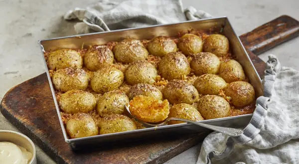 Ugnsbakade, krossade potatisar med parmesan och örter, redo att serveras.