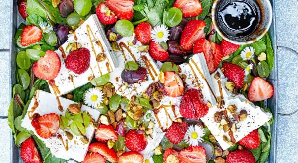 Sommarfräsch sallad med jordgubbar och fetaost, gröna druvor, nötter och en balsamico-dressing.