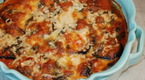 En ugnsbakad auberginegratäng med tomatsås och smält ost. Ett perfekt aubergine recept för middagen.