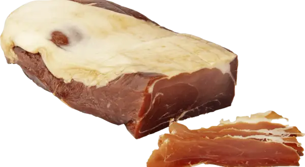 En bit prosciutto crudo med tunt skivad skinka bredvid.