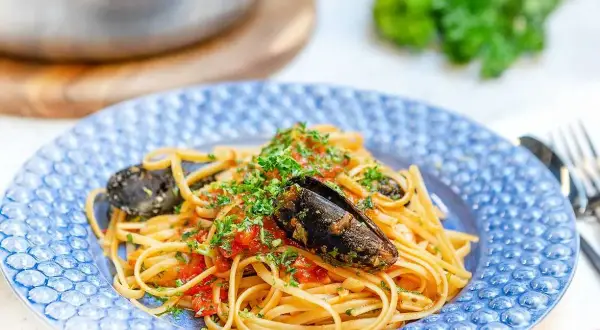 En tallrik med spaghetti allo scoglio, toppad med färska örter och musslor. En härlig italiensk pastarätt.