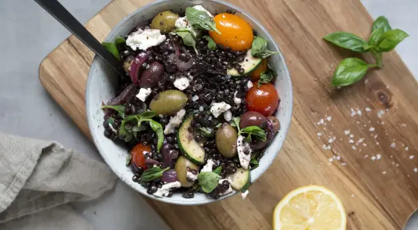 En härlig linssallad med svarta linser, fetaost, oliver, tomater och zucchini. Ett perfekt recept för en lätt och smakrik måltid.