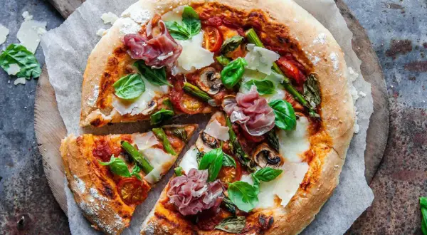 En härlig italiensk pizza med sparris, parmaskinka, champinjoner och färsk basilika.