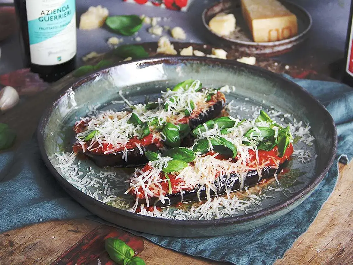 Aubergine i ugn, toppad med tomatsås, basilika och rikligt med riven ost. En läcker och smakrik rätt.