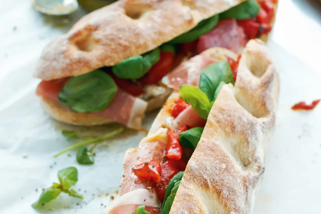 Två läckra panini med prosciutto, tomater och basilika. Ett perfekt panini recept för en snabb och smakrik lunch.
