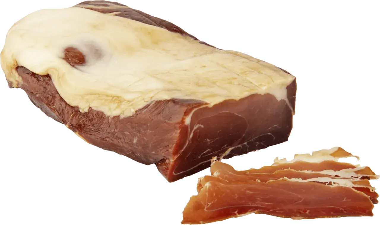 En bit prosciutto crudo med tunt skivad skinka bredvid.
