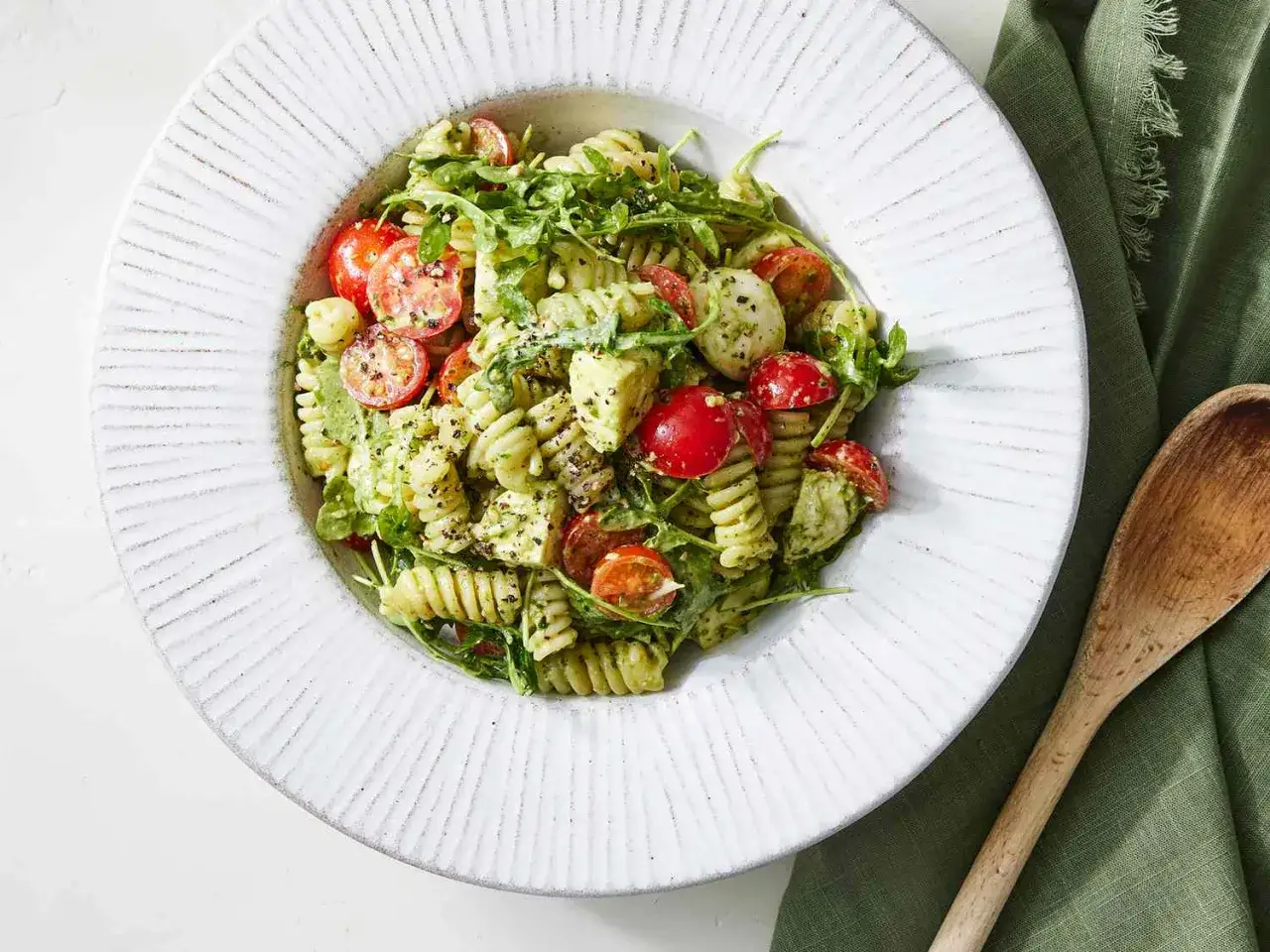 En härlig italiensk pastasallad med pesto, körsbärstomater, mozzarella och ruccola. Perfekt för en lätt lunch.