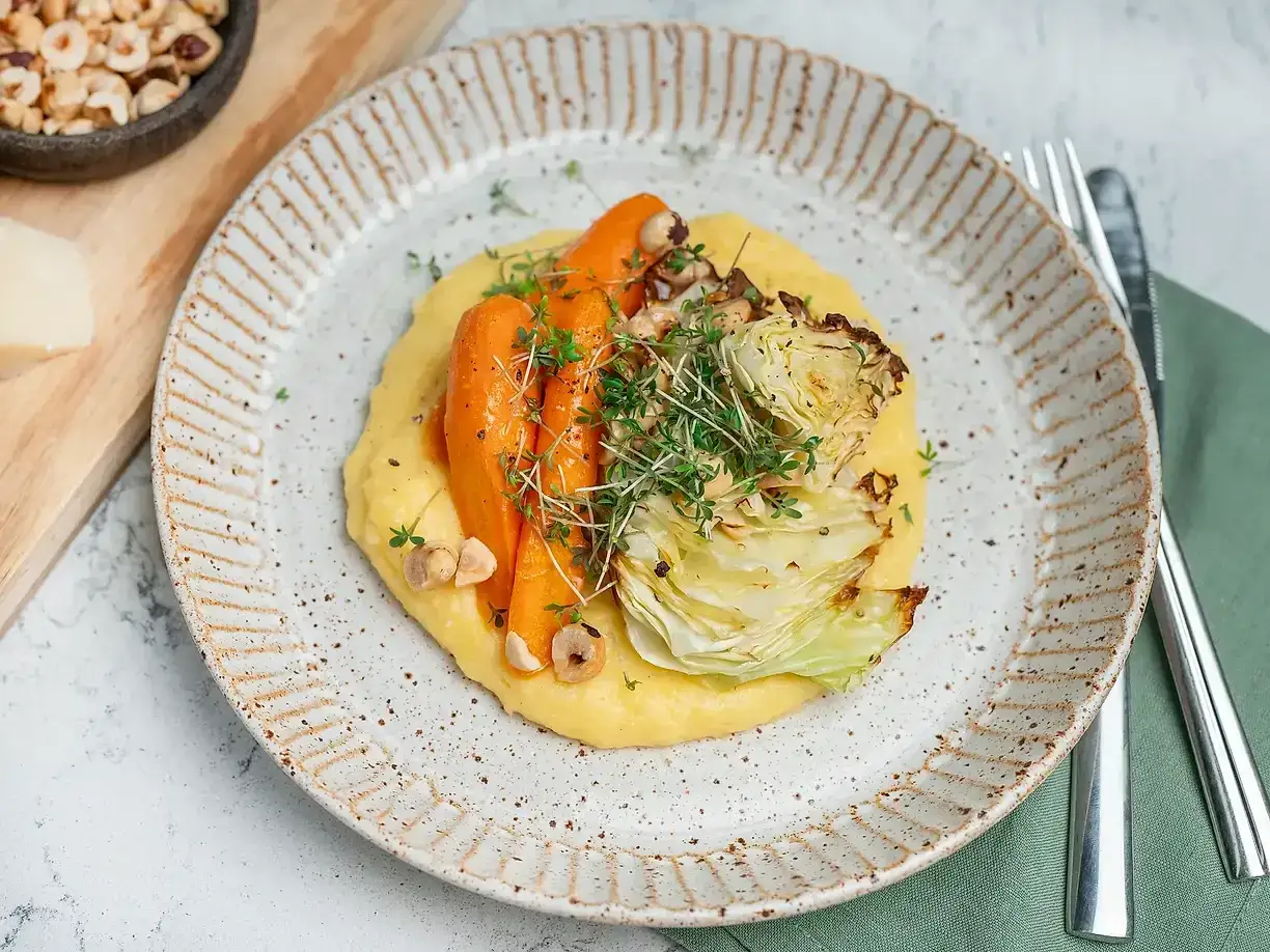 En krämig polenta med rostade rotfrukter och krispiga hasselnötter. Ett enkelt och gott polenta recept.