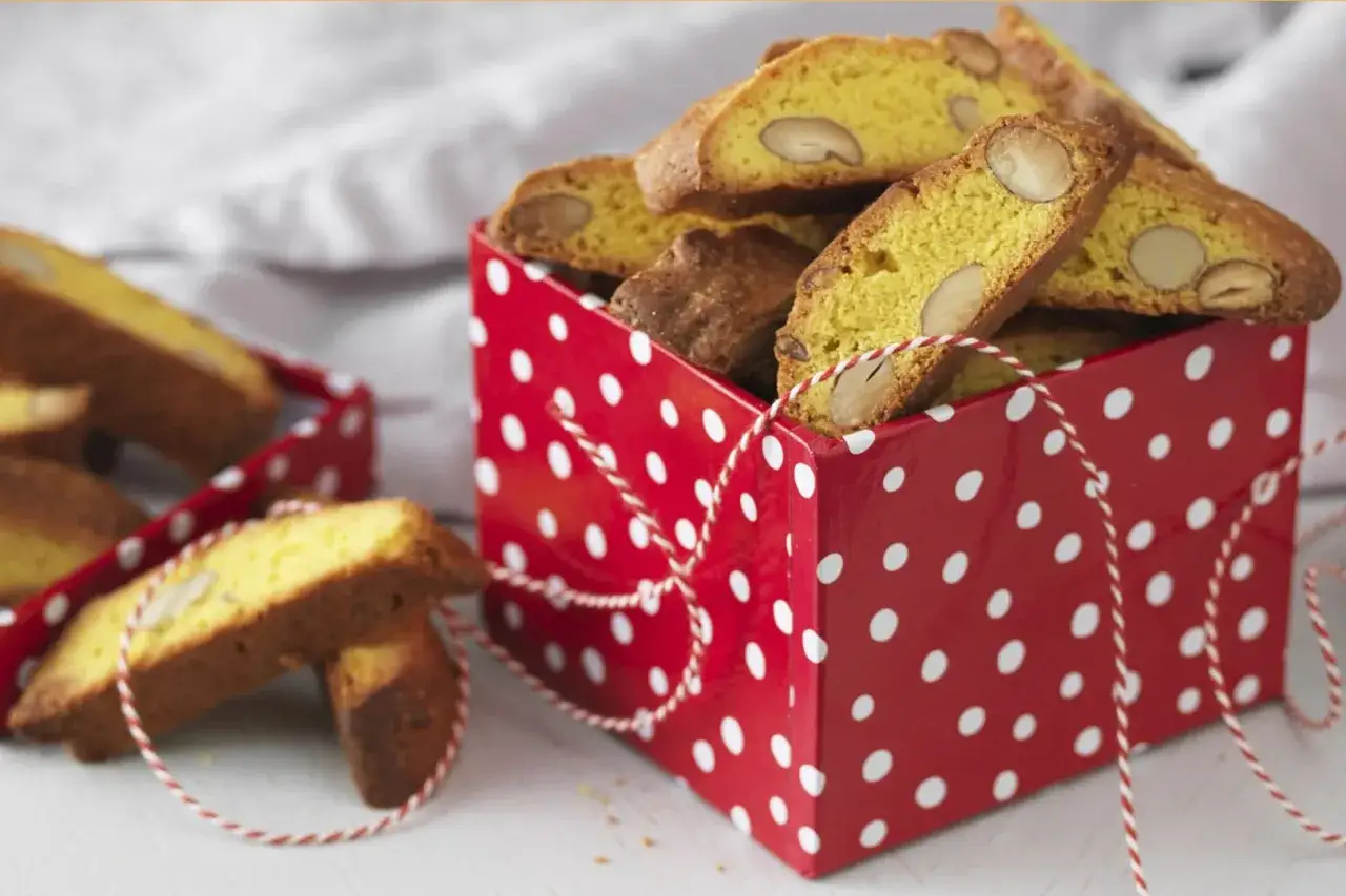 En röd prickig låda fylld med saffransbiscotti med mandel. En härlig juldoft sprider sig.