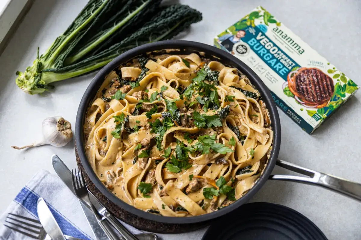 Krämig vegetarisk carbonara med tagliatelle, grönkål och svamp. Bredvid syns en förpackning med vegoburgare.