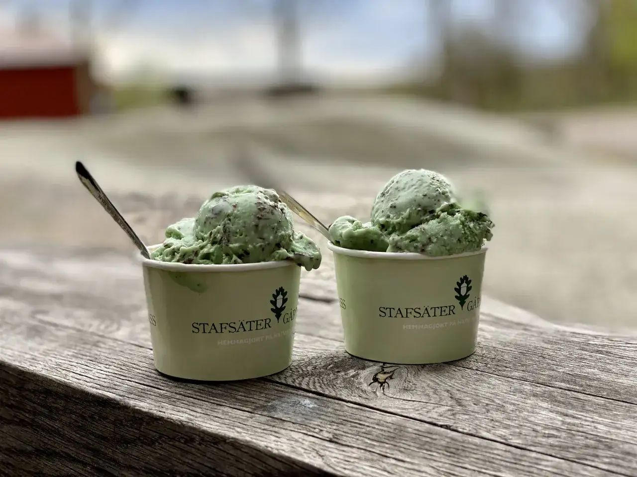 Två muggar med krämig italiensk glass, mintchokladsmak, står på ett träbord.