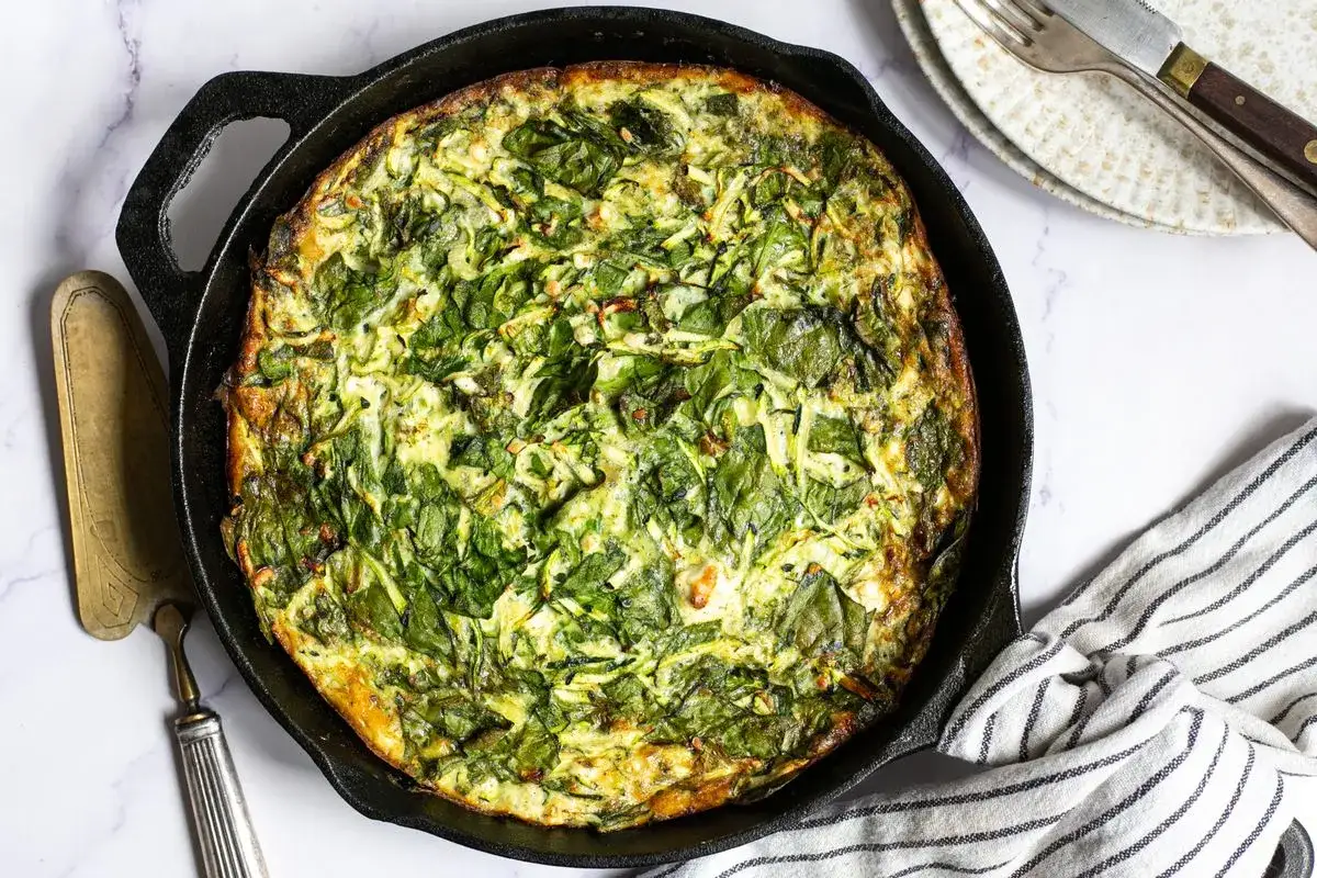 En saftig frittata med spenat och zucchini, perfekt för ett snabbt och gott frittata recept. Serveras direkt ur gjutjärnspannan.