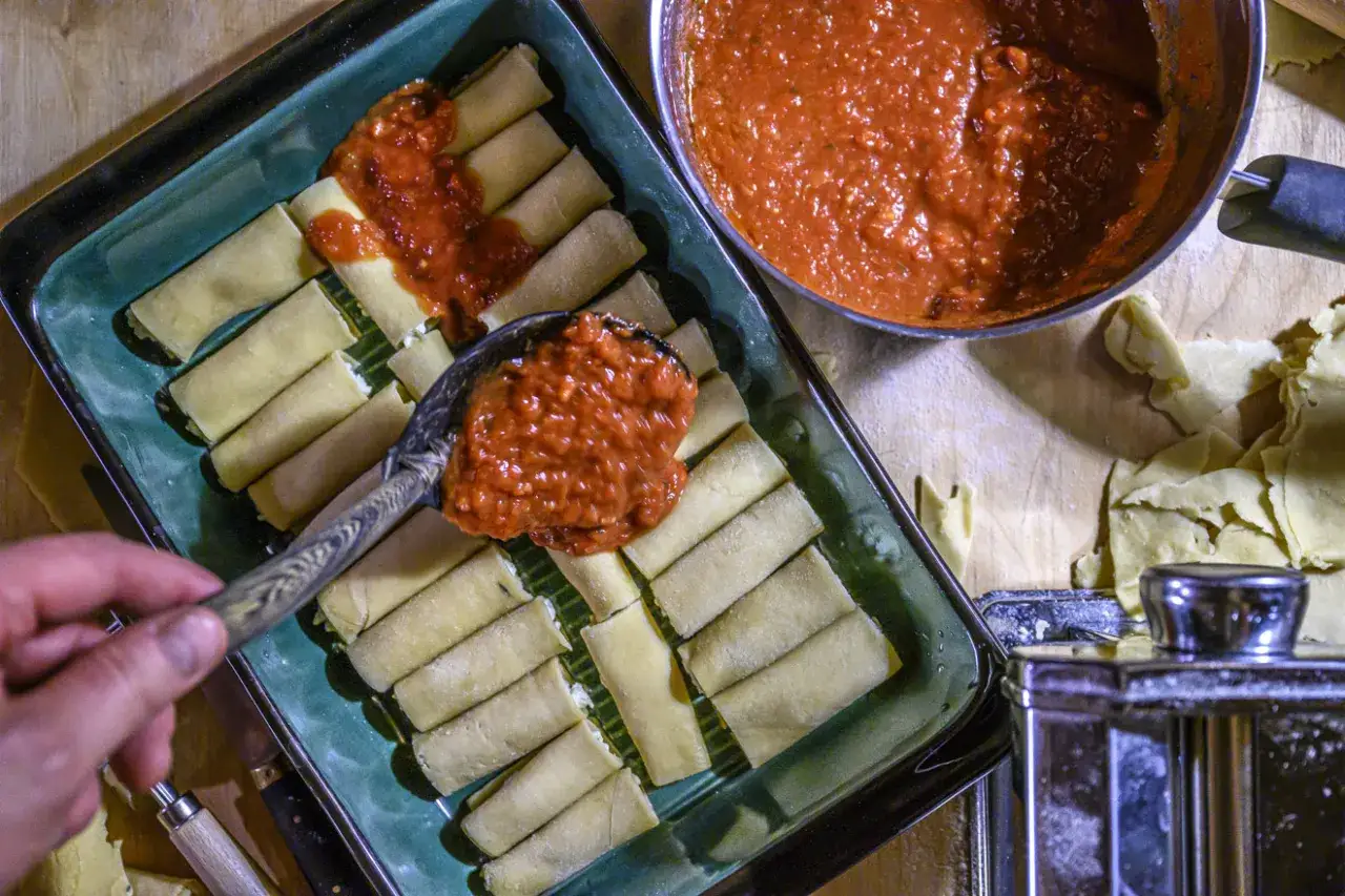 Fyller cannelloni med tomatsås, ett steg i ett läckert cannelloni recept.