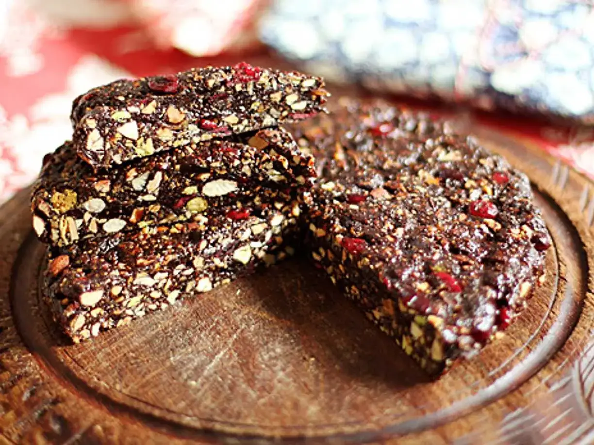 En bit av ett mörkt, nötigt bakverk med torkade bär, perfekt för ett panforte recept.
