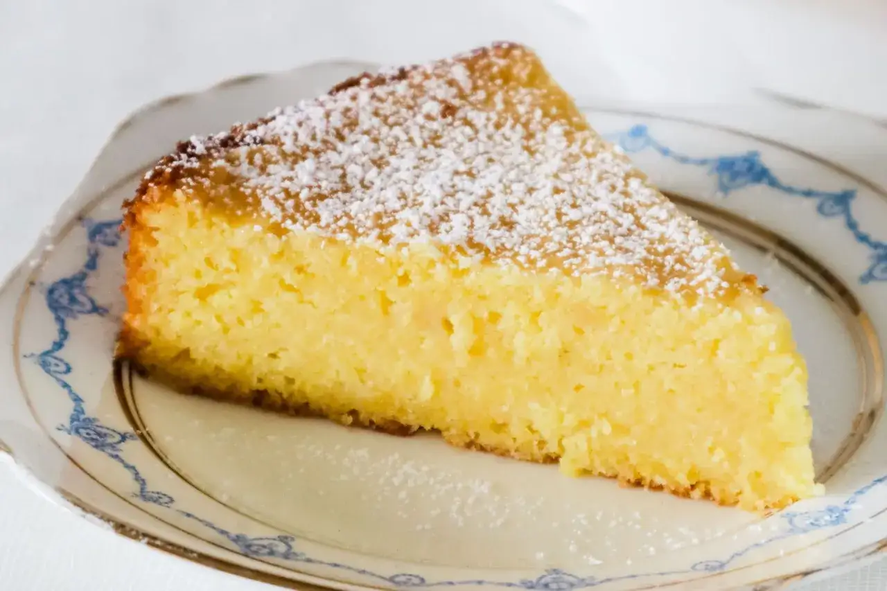 En bit fluffig italiensk dessert med citron, pudrad med florsocker på en vacker tallrik.