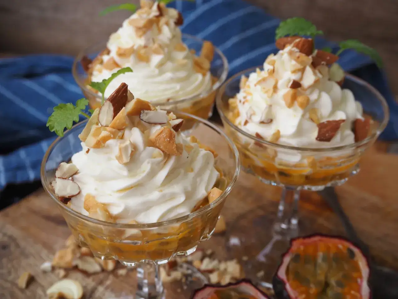 Tre eleganta glas med kr&auml;mig mascarpone dessert, toppad med mandel och mynta. Passionsfrukt i botten ger en tropisk touch.