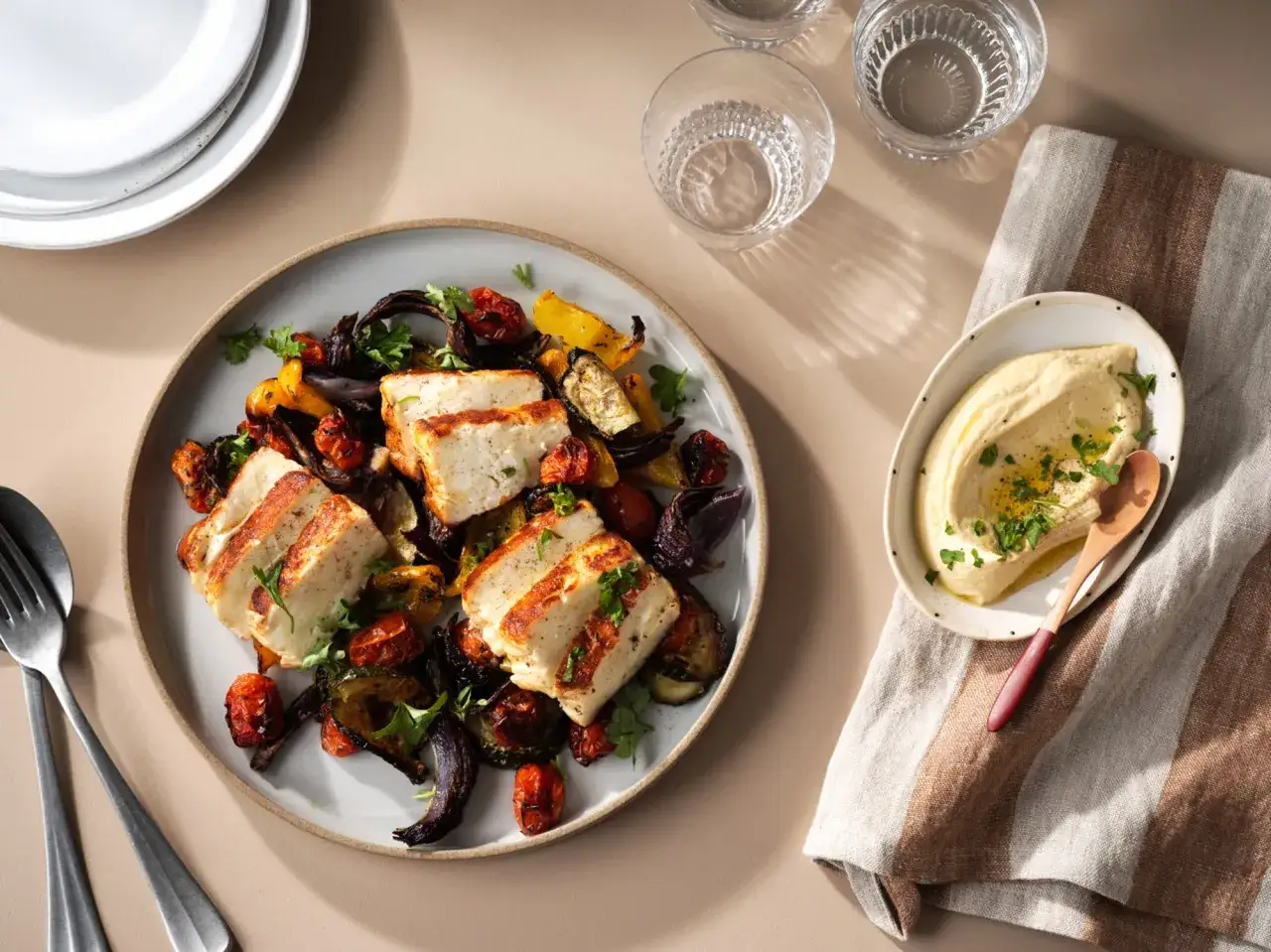 Grillad halloumi med rostade grönsaker och en klick krämig hummus. Ett perfekt halloumi recept för en lätt och smakrik måltid.