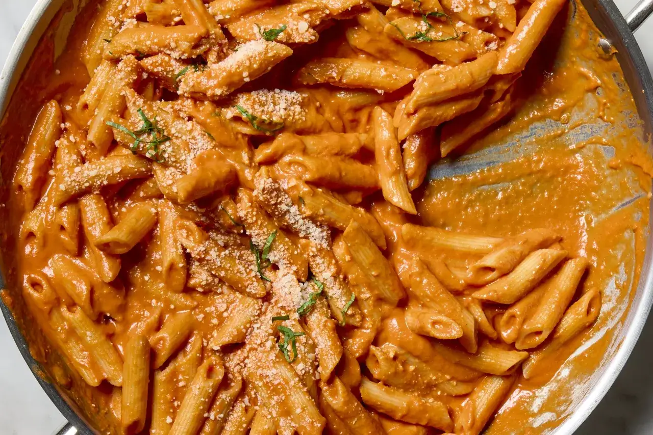 Krämig penne med en härlig tomatsås, perfekt för ett snabbt och gott vodka pasta recept. Toppad med parmesan och basilika.