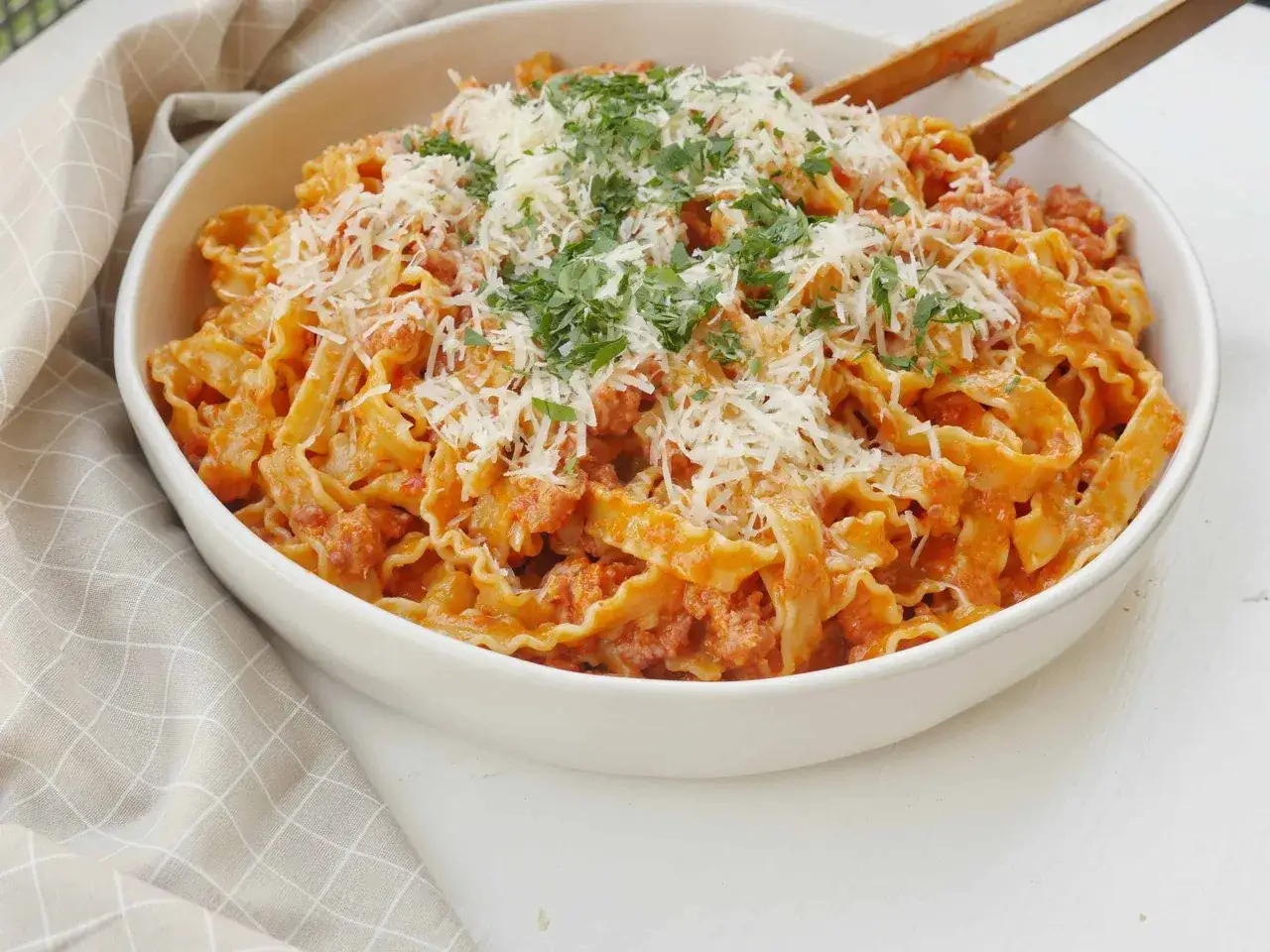 En skål med krusig pasta i en krämig tomatsås, toppad med riven ost och färsk persilja. En härlig pasta alla norcina som ser utsökt ut.