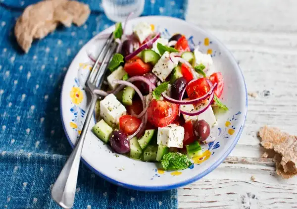 En fräsch grekisk sallad med fetaost, tomater, gurka, oliver och rödlök, perfekt med en lätt grekisk sallad dressing.