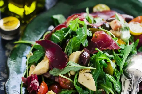 En härlig typisk italiensk sallad med ruccola, lufttorkat kött, oliver, kronärtskocka och tomater.