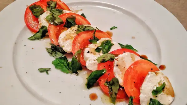 Caprese-sallad med skivade tomater, färsk mozzarella och basilika. Ett enkelt och gott mozzarella recept.