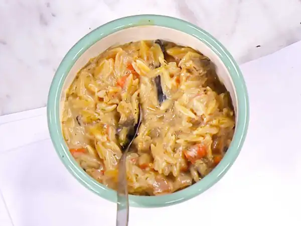 En skål med krämig risonipasta med grönsaker. Perfekt för att koka risoni till en snabb och god middag.